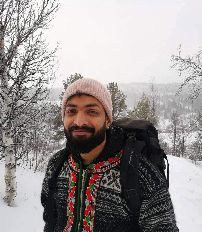 Arjun Ajith outdoors in Sunnmøre in winter, in a Norwegian knitted sweater